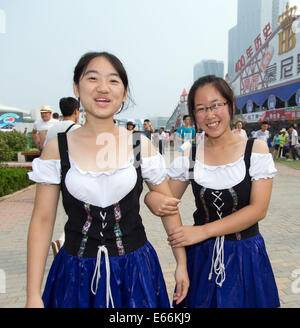 Qingdao, China. 16. August 2014. Zwei Frauen tragen bayerische Dirndl am 24. Oktoberfest in Qingdao, China, 16. August 2014. Laut Veranstalter ist es zum größten Volksfest in Asien. Foto: FRISO GENTSCH/Dpa/Alamy Live News Stockfoto