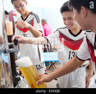 Qingdao, China. 16. August 2014. Kellner Gießen Bier in einem Festzelt beim 24. Oktoberfest in Qingdao, China, 16. August 2014. Laut Veranstalter ist es zum größten Volksfest in Asien. Foto: FRISO GENTSCH/Dpa/Alamy Live News Stockfoto