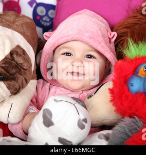 Ein kleines Mädchen zwischen vielen Teddys Stockfoto