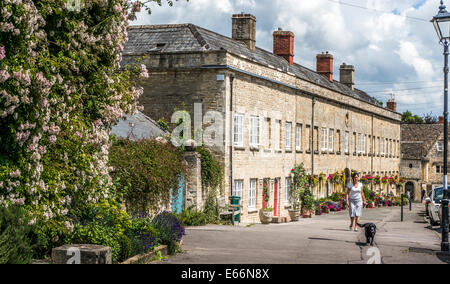 Frau zu ihrem Hund nach Periode Häuser in die Parade der Tontine Gebäude, Cecily Hill, Cirencester, Cotswolds, Gloucestershire, England, UK. Stockfoto