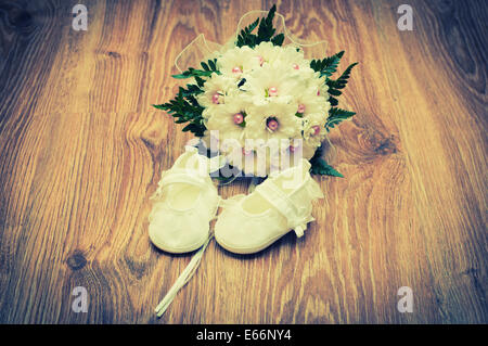 Weiße Schuhe und weiße Bouquet auf einem Holzfußboden Stockfoto