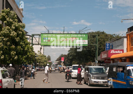 Menschen und Verkehr auf Kenyatta Avenue Nakuru Kenia in Ostafrika mit Werbung Horten für 3g Netzwerk Stockfoto