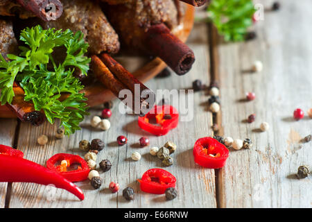 Traditionelles Lamm Kebab auf Zimt-sticks auf Holzplatte mit roten Paprika, Tomaten und Petersilie. Selektiven Fokus. Stockfoto