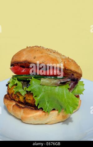 Vegetarische Kichererbsen, Mais und Karotten-Burger mit Salat in einem Sesam Brötchen, UK. Stockfoto