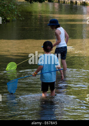 Zwei jungen Fischen mit Netzen in den Fluss, Bourton auf dem Wasser, Gloucestershire, UK Stockfoto