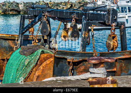 Fischerboot mit schweren Angelausrüstung, verrostete und verwitterte Ketten Seile Umlenkrollen und Fischernetze vertäut Eden Harbour, New South Wales Stockfoto