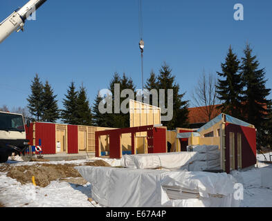 Bau eines Holzhauses im Winter im sonnigen Ambiente Stockfoto