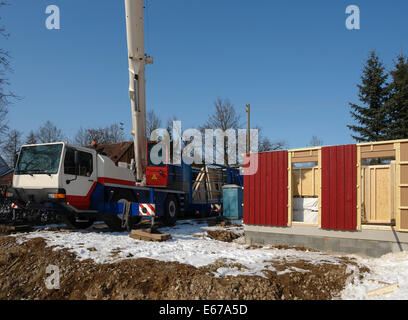 Bau eines Holzhauses im Winter im sonnigen Ambiente Stockfoto