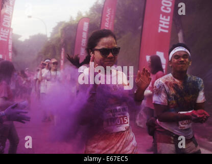 Kuala Lumpur, Malaysia.  17. August 2014. Ein Teilnehmer reagiert wie sie laufen durch bunte Pulver von Freiwilligen während CIMB Color Run am 17. August 2014 in Kuala Lumpur geworfen. Color-Run, auch bekannt als der glücklichste 5 k zum ersten Mal in Malaysia statt zieht Tausende von Läufern aus verschiedenen Gruppe, Alter und ethnische. Bildnachweis: Kamal Sellehuddin/ZUMA Draht/Alamy Live-Nachrichten Stockfoto