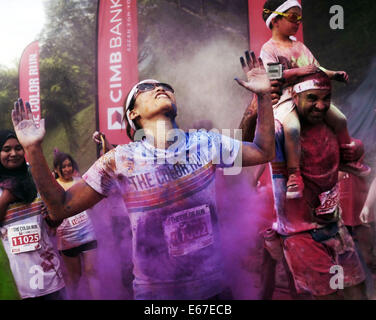 Kuala Lumpur, Malaysia.  17. August 2014. Ein Teilnehmer reagiert wie sie laufen durch bunte Pulver von Freiwilligen während CIMB Color Run am 17. August 2014 in Kuala Lumpur geworfen. Color-Run, auch bekannt als der glücklichste 5 k zum ersten Mal in Malaysia statt zieht Tausende von Läufern aus verschiedenen Gruppe, Alter und ethnische. Bildnachweis: Kamal Sellehuddin/ZUMA Draht/Alamy Live-Nachrichten Stockfoto