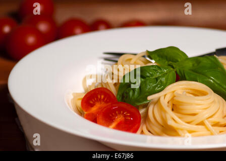 Spaghetti oder Nudeln mit Tomaten und Fleisch auf Holztisch Stockfoto