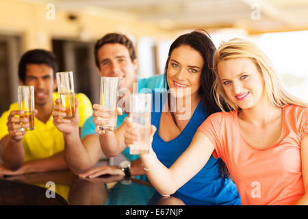 vier glückliche Freunde, die Getränke an der bar Stockfoto