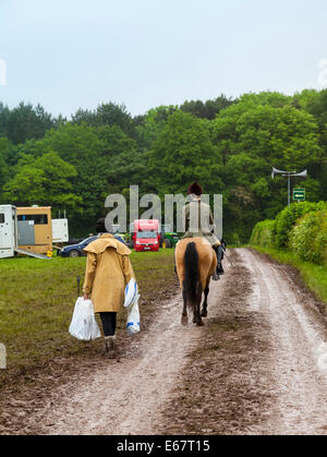 Staffordshire England Frau auf dem Pferd Reiten hinunter Landstraße, mit älteren Frau zu Fuß nach, Einkaufstaschen tragen Stockfoto