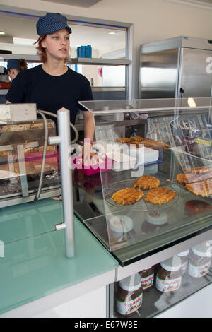 Ein Assistent wartet auf ihre nächste Waffel-Bestellung bei Hochbetrieb Eishaus, Albert Promenade, Ostende. Stockfoto