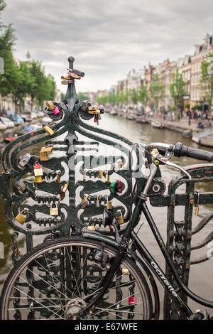 Fahrrad und Liebe Schlösser in einer Brücke in Amsterdam, Holland, Europa Stockfoto