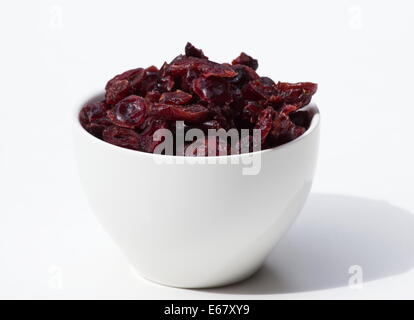 Getrocknete Cranberries in einer weißen Schüssel auf weißem Hintergrund Stockfoto