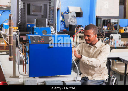 Student im Rollstuhl studieren Erdgas Kraftstoffleitung am Ofen in HLK-Klasse Stockfoto