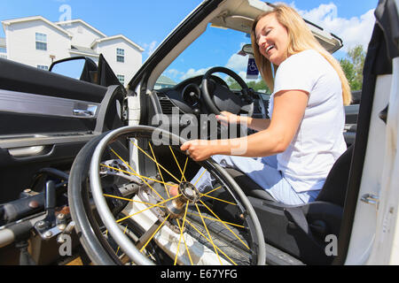 Frau mit Verletzungen des Rückenmarks ziehen Rollstuhl in ihrem adaptiven Fahrzeug Stockfoto