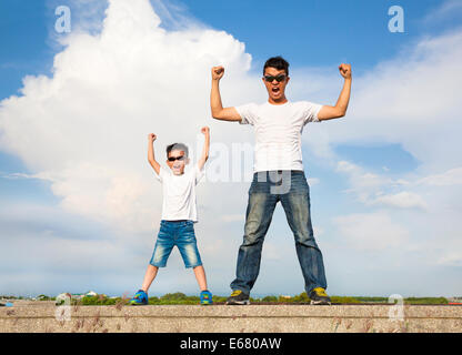 Vater und Sohn stehen und Hände erhebend Stockfoto