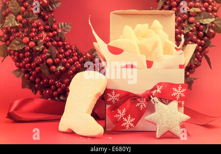 Weihnachts-Geschenk-Box von Keks von Spritzgebäck mit festlichen Schmuck Dekorationen ausgelassen für Santa mit Retro-Vintage-Filter. Stockfoto