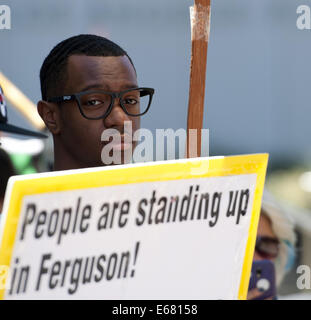 Los Angeles, Kalifornien, USA. 17. August 2014. Ein junger Mann hält ein Protest-Schild, die Unterstützung der Fersuson vor dem LAPD Hauptquartier am Sonntagnachmittag liest. ---Rund 800 Demonstranten versammelten sich vor dem Los Angeles Police Department in der Innenstadt am Sonntagnachmittag zu protestieren, der Offizier beteiligt schießen ein Ezell Ford in South Central Los Angeles letzte Woche auch verdeutlichen unterstützen die Bewohner von Ferguson, Missouri, bei ihren Protesten gegen die Polizei dort. Die versammelten Menge angezeigt, Plakate und Schilder mit Parolen gegen die Polizei Verbindungstechnik zusammen, um ihre Sup chant Stockfoto