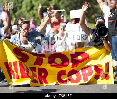 Los Angeles, Kalifornien, USA. 17. August 2014. Eine junge Frau hält einen Banner, als sie mit etwa 450 Demonstranten in ging eine Straße marschieren rund um Los Angeles downtown am Sonntag Nachmittag.---ca. 800 Demonstranten versammelten sich vor der Los Angeles Police Department in der Innenstadt am Sonntag Nachmittag zu protestieren, der Offizier beteiligt Dreharbeiten eine Ezell Ford in South Central Los Angeles Vorwoche, sowie Unterstützung der Bewohner von Ferguson , Missouri, bei ihren Protesten gegen die Polizei dort. Die versammelten Menge angezeigt, Plakate und Schilder mit Parolen gegen die Polizei, Beitritt Stockfoto