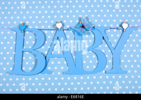 Baby Boy Kindergarten Blau BABY Buchstaben Bunting hängend Heringe auf einer Linie vor dem Hintergrund des blauen Tupfen Stockfoto