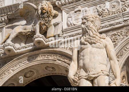 Nahaufnahme der Statue des Neptun mit geflügelten Löwen von Venedig an der Spitze der Treppe der Riese in den Dogenpalast. Stockfoto