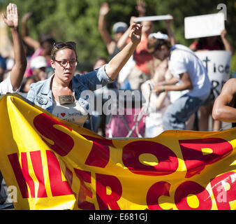 Los Angeles, Kalifornien, USA. 17. August 2014. Eine junge Frau hält einen Banner, als sie mit etwa 450 Demonstranten in ging eine Straße marschieren rund um Los Angeles downtown am Sonntag Nachmittag.---ca. 800 Demonstranten versammelten sich vor der Los Angeles Police Department in der Innenstadt am Sonntag Nachmittag zu protestieren, der Offizier beteiligt Dreharbeiten eine Ezell Ford in South Central Los Angeles Vorwoche, sowie Unterstützung der Bewohner von Ferguson , Missouri, bei ihren Protesten gegen die Polizei dort. Die versammelten Menge angezeigt, Plakate und Schilder mit Parolen gegen die Polizei, Beitritt Stockfoto