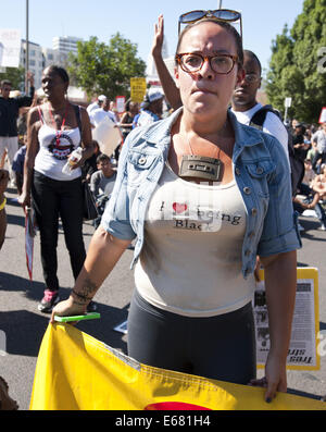Los Angeles, Kalifornien, USA. 17. August 2014. Eine junge Frau hält einen Banner, als sie mit etwa 450 Demonstranten in ging eine Straße marschieren rund um Los Angeles downtown am Sonntag Nachmittag.---ca. 800 Demonstranten versammelten sich vor der Los Angeles Police Department in der Innenstadt am Sonntag Nachmittag zu protestieren, der Offizier beteiligt Dreharbeiten eine Ezell Ford in South Central Los Angeles Vorwoche, sowie Unterstützung der Bewohner von Ferguson , Missouri, bei ihren Protesten gegen die Polizei dort. Die versammelten Menge angezeigt, Plakate und Schilder mit Parolen gegen die Polizei, Beitritt Stockfoto