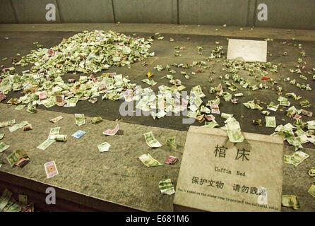 Peking, China. 14. August 2014. 14. AUGUST: Die Leute werfen Kleingeld Sarg schlafen wie sie für eine bessere Zukunft im unterirdischen Palast der Dingling Grab, das Mausoleum von Kaiser Zhu Yijun (1563-1620) der Ming-Dynastie, am 14. August 2014 in Peking, China beten. © SIPA Asien/ZUMA Draht/Alamy Live-Nachrichten Stockfoto