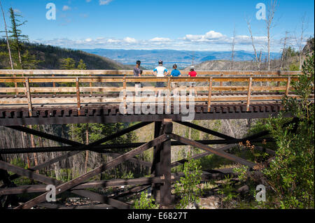 Mountain Biken Radfahren Reiten die alten Holzeisenbahn Böcke Trail in den Myra Canyon, Kelowna, British Columbia, Kanada. Stockfoto