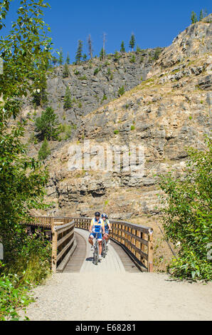 Mountain Biken Radfahren Reiten die alten Holzeisenbahn Böcke Trail in den Myra Canyon, Kelowna, British Columbia, Kanada. Stockfoto