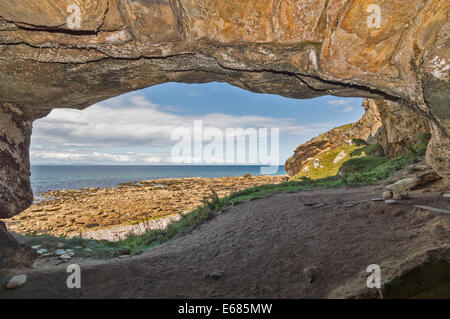 BILDHAUER HÖHLENEINGANG MORAY KÜSTE SCHOTTLANDS IN DER NÄHE VON HOPEMAN DEN BLICK AUF DEN STRAND UND DAS MEER DES MORAY FIRTH Stockfoto