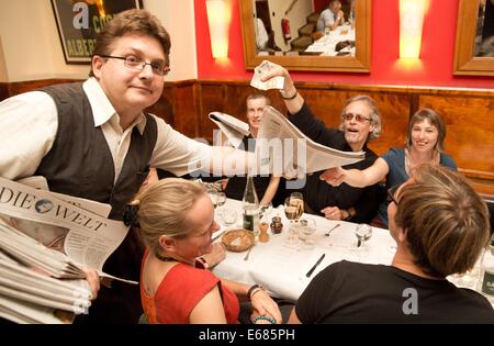 Berlin, Deutschland. 31. Juli 2014. Der poetische Reporter Holger Bleck (L) ist in einem Restaurant in Berlin, Deutschland, 31. Juli 2014 abgebildet. Bleck poetises in verschiedenen Restaurants und ist auf seinem Weg bis Mitternacht. Foto: Jörg Carstensen/Dpa/Alamy Live News Stockfoto