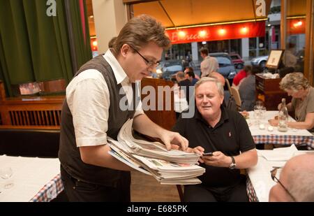 Berlin, Deutschland. 31. Juli 2014. Der poetische Reporter Holger Bleck (L) ist in einem Restaurant in Berlin, Deutschland, 31. Juli 2014 abgebildet. Bleck poetises in verschiedenen Restaurants und ist auf seinem Weg bis Mitternacht. Foto: Jörg Carstensen/Dpa/Alamy Live News Stockfoto