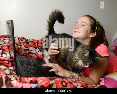 Computer Laptop verwendet wird, von einem Kind in ihr Schlafzimmer, teenage Girl mit einem Computer Laptop allein in ihrem Zimmer Stockfoto