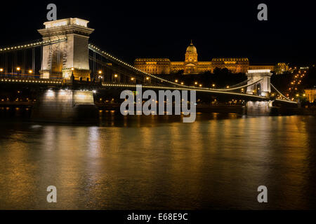 Kettenbrücke Budapest Ungarn beleuchtet in der Nacht mit der Budaer Burg im Hintergrund Stockfoto