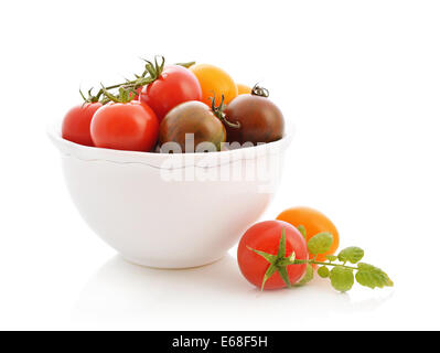 Verschiedene Sorten von Tomaten in Schüssel isoliert auf weiss Stockfoto
