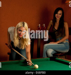 Schöne junge Blondine in einer Bar Billard spielen Stockfoto