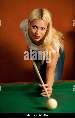 Schöne junge Blondine in einer Bar Billard spielen Stockfoto