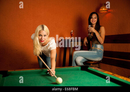 Schöne junge Blondine in einer Bar Billard spielen Stockfoto