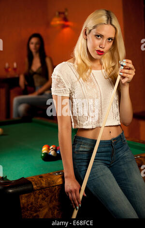 Schöne junge Blondine in einer Bar Billard spielen Stockfoto