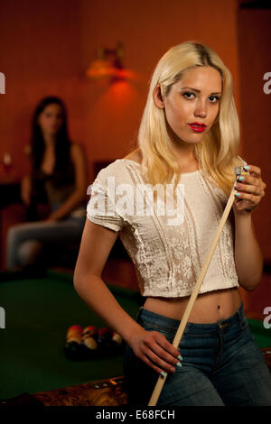 Schöne junge Blondine in einer Bar Billard spielen Stockfoto