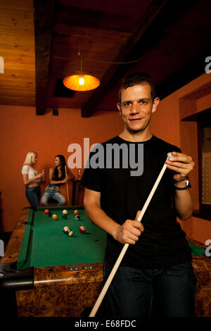 Mann spielt Billard in einer Bar in der Nacht Stockfoto