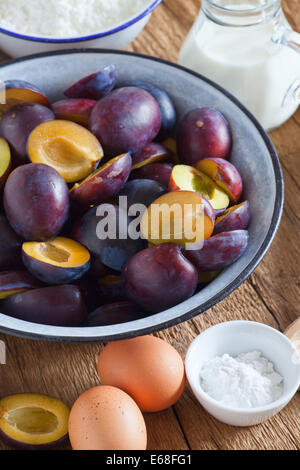 Zutaten zu einer Pflaume Kuchen auf einem rustikalen Holztisch Stockfoto