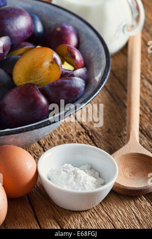 Zutaten zu einer Pflaume Kuchen auf einem rustikalen Holztisch Stockfoto