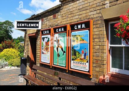 Alte Werbung Plakate an der Bahn Bahnhof Wand mit den Herren Toiletten am Ende, Severn Valley Railway, Arley, UK. Stockfoto