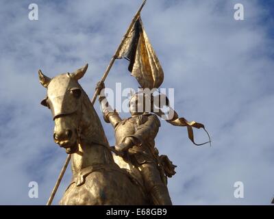 Eine Statue von Jeanne d'Arc, der französischen Heldin und heiligen, auf dem Pferd dargestellt. Die Statue hat goldene Akzente und ein Banner, das ihre Rolle in der französischen Geschichte und ihre Heiligkeit symbolisiert. Stockfoto