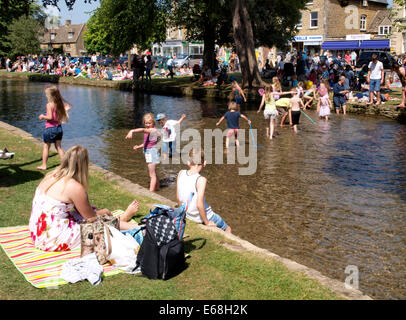 Menschen genießen die Hitzesommer von River Windrush, Bourton-on-the-Water, Gloucestershire, Großbritannien 30.07.2014 Stockfoto